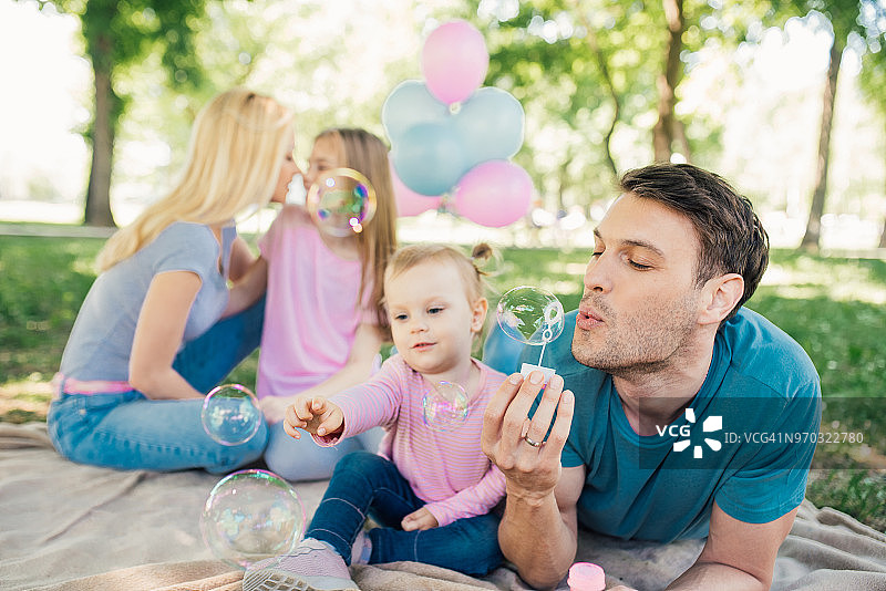 父亲吹泡泡，女婴捕捉泡泡图片素材