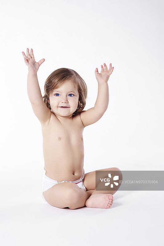 穿着尿布的儿童举起双手（波兰德比察，影棚拍摄）图片素材