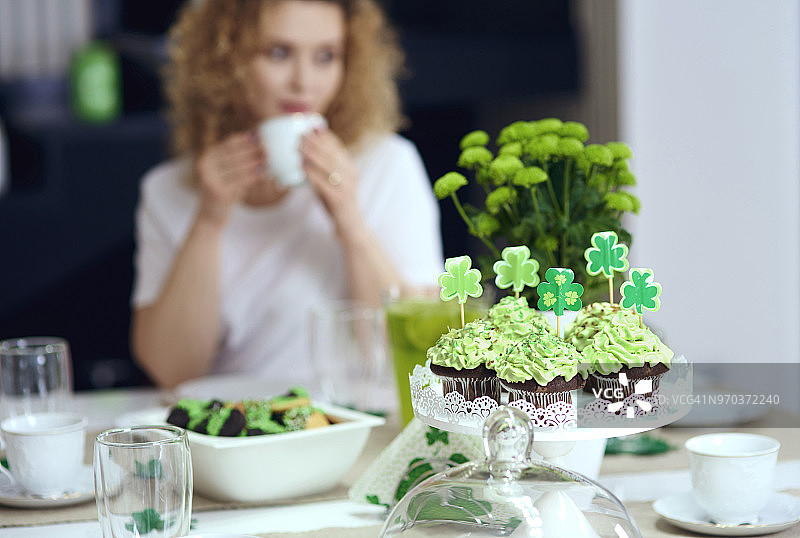 爱尔兰派对上的纸杯蛋糕桌子和背景中的女人（波兰德比察）图片素材
