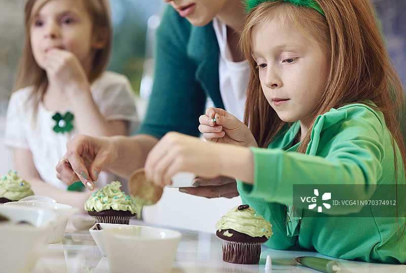 全家在厨房装饰纸杯蛋糕，波兰德比察图片素材