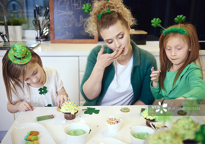 母亲和孩子们在厨房装饰纸杯蛋糕，波兰德比察图片素材