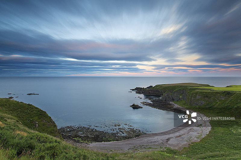 苏格兰海岸邓诺特城堡的日落和流动的云彩图片素材
