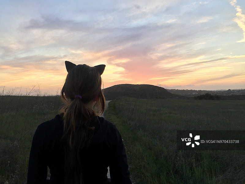 戴着猫耳朵望向地平线的女孩图片素材