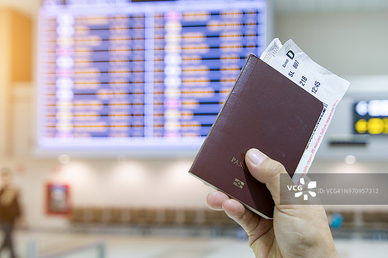 男人在机场手持护照和登机牌的特写图片素材