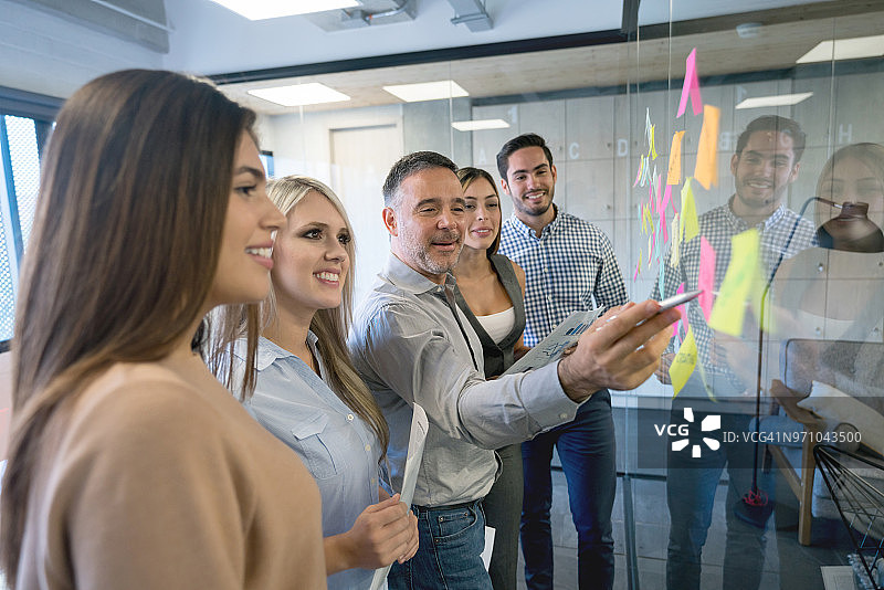 一群人在创意办公室集思广益，使用便利贴图片素材