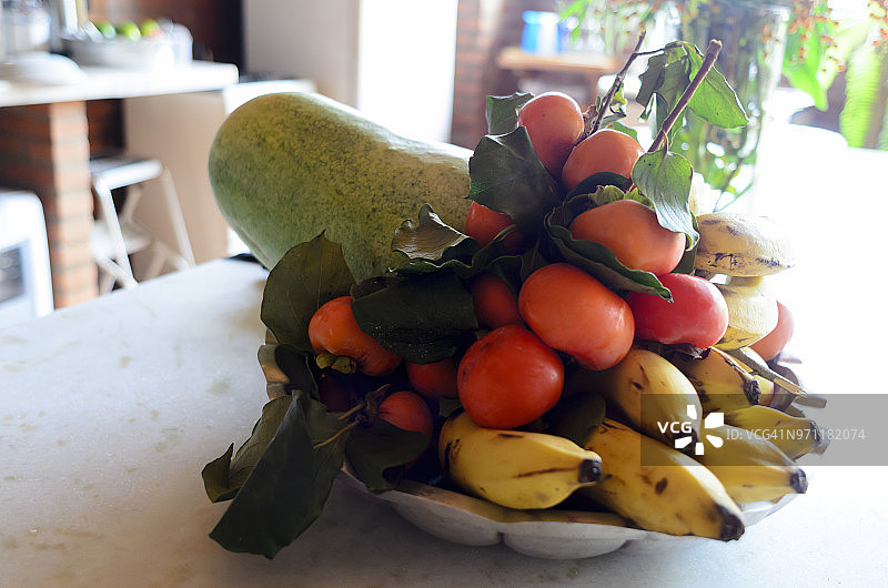 高分辨率横版照片：巴西热带水果篮，香蕉、柿子、菠萝、木瓜，浅色背景图片素材