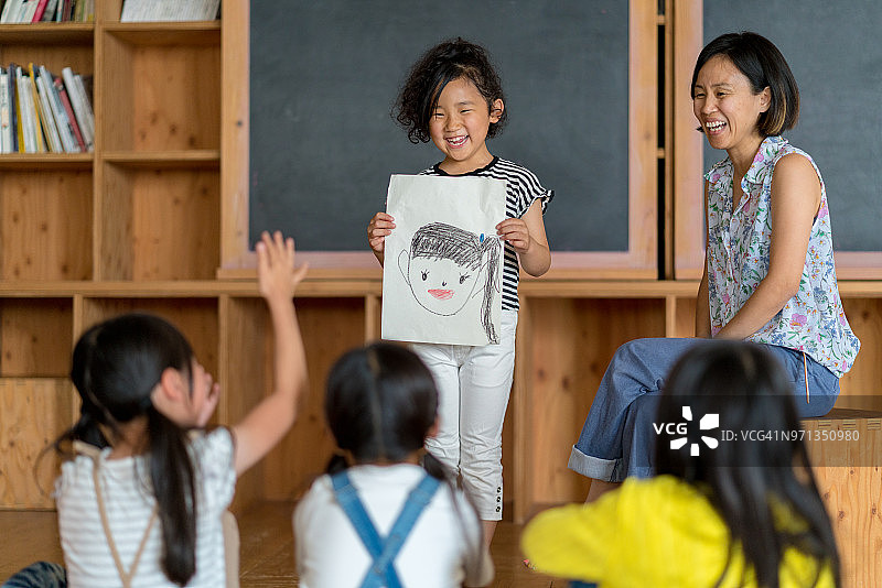 年轻女学生在课堂上做演示图片素材