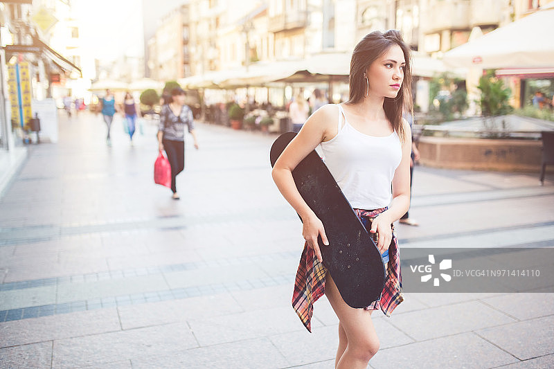女孩抱着她的滑板图片素材