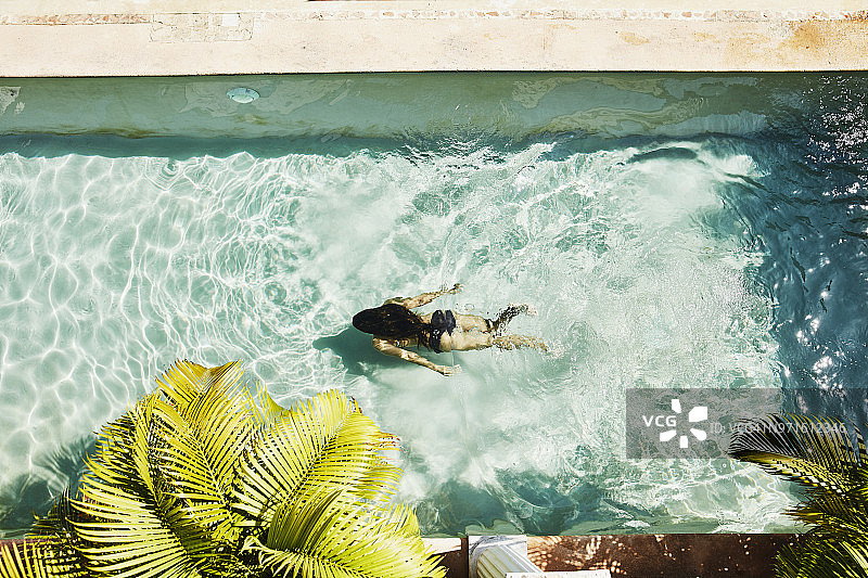 在水疗中心户外泳池中水下游泳的女子俯视图图片素材