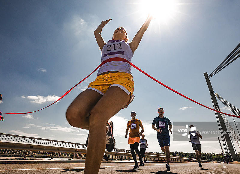 成功的马拉松运动员冲过终点线图片素材