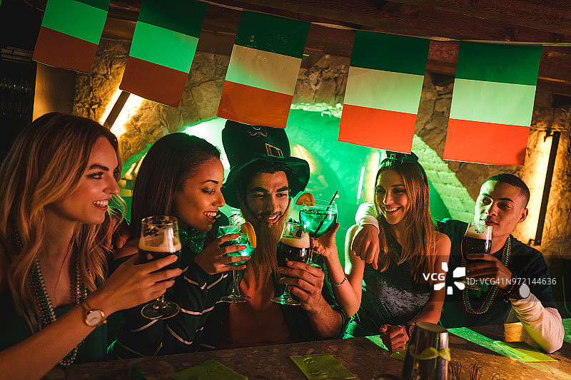 年轻的多种族朋友在爱尔兰酒吧庆祝圣帕特里克节图片素材