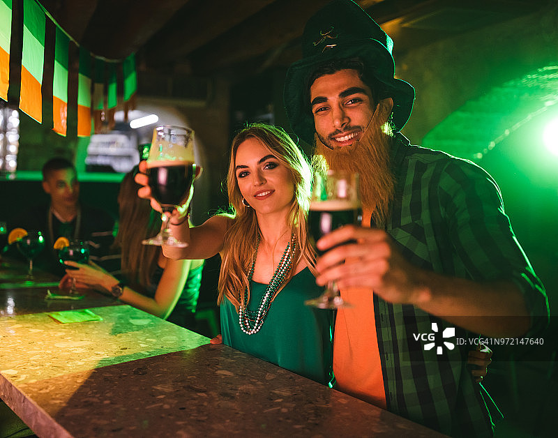 在圣帕特里克节用饮品庆祝的幸福情侣图片素材