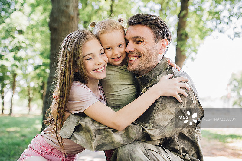 年轻女孩拥抱一名士兵图片素材
