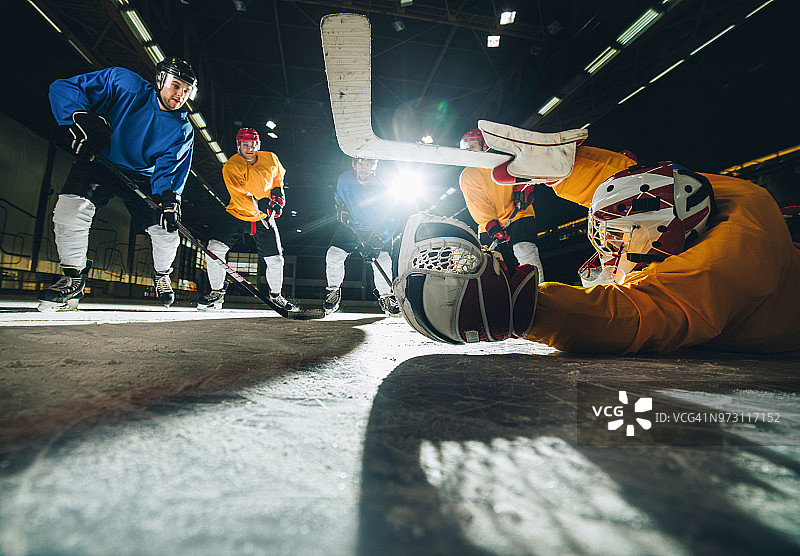 冰球比赛中守门员和冰球运动员的动作图片素材