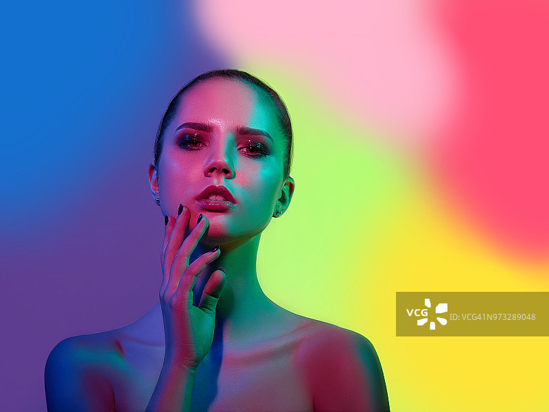 在演播室中以彩色灯光摆姿势的高级时装模特图片素材