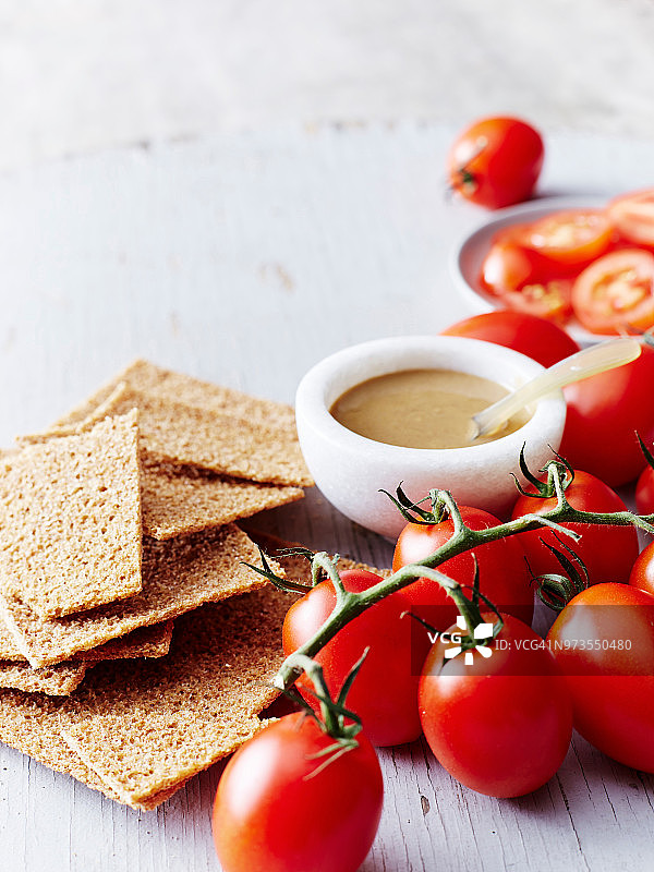 芝麻酱、黑麦饼干和葡萄番茄静物图片素材