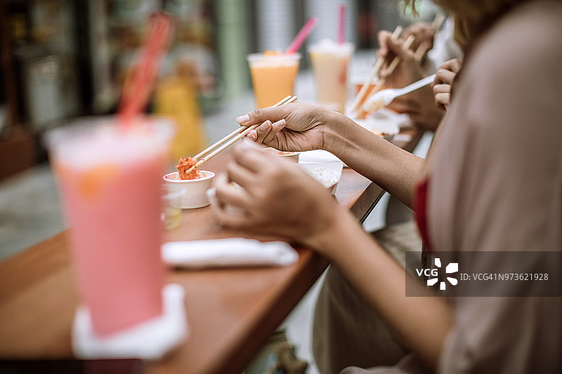 三名女性朋友品尝异国亚洲美食图片素材