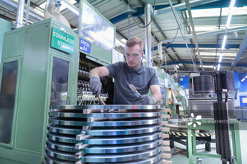 工程师在金属冲压厂将钢材装入冲压机图片素材