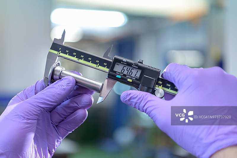 工程师在金属冲压厂测量冲压件图片素材