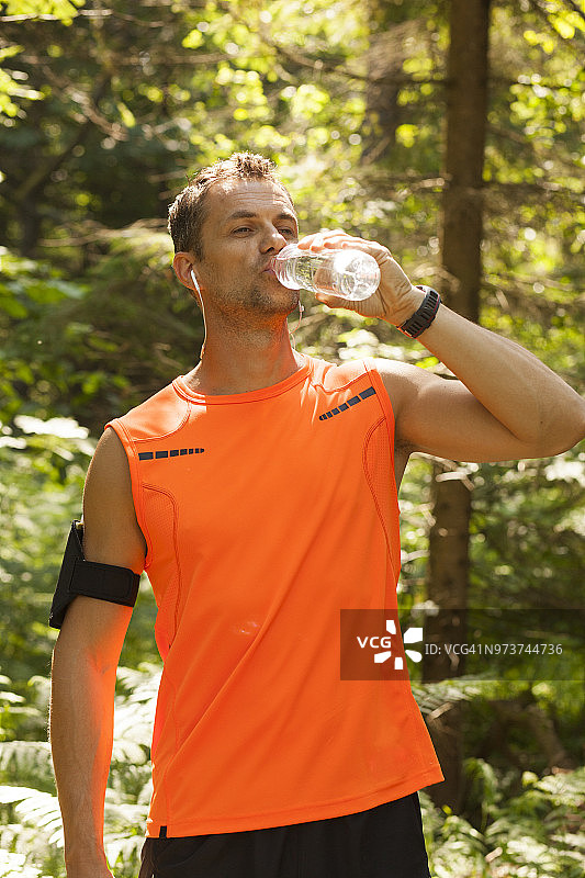 跑步者在森林里休息和喝水图片素材
