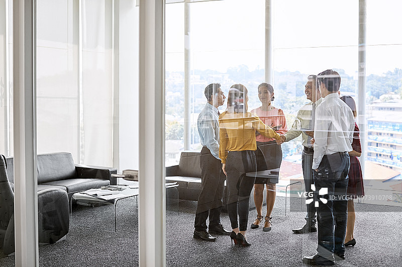 专业人士透过玻璃握手图片素材