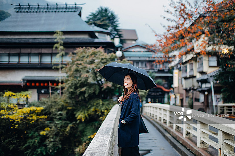 亚洲女性游客在日本箱根老街欣赏美丽的红枫叶图片素材