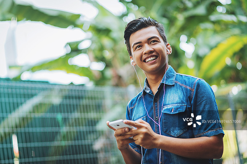 无忧无虑的年轻马来西亚男子听播客图片素材