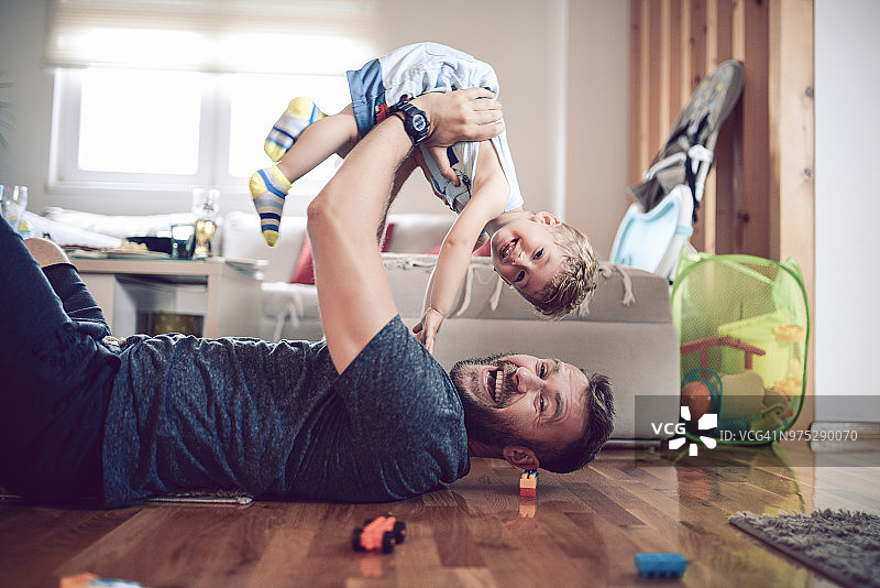 父亲在客厅里和儿子玩耍图片素材