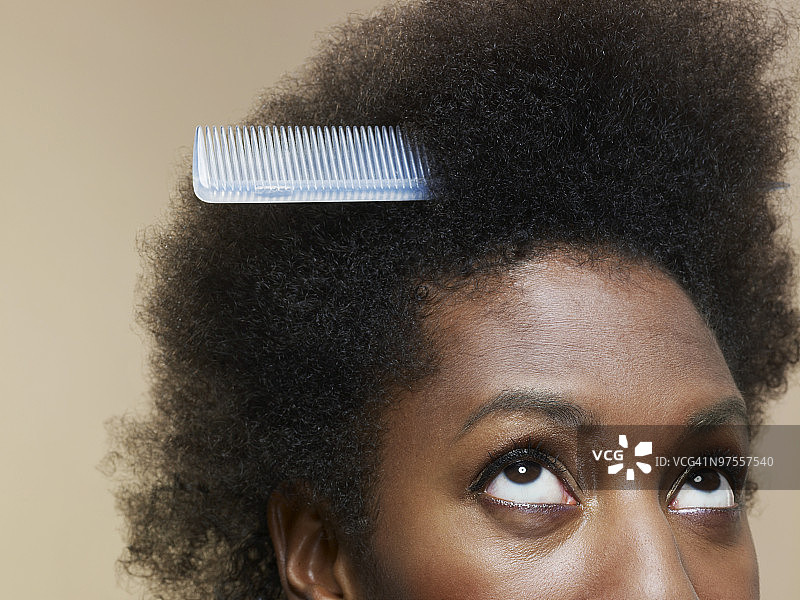 女人看着头发里的梳子图片素材
