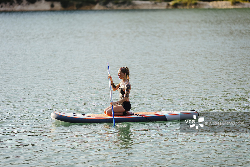 年轻女子在划桨板上图片素材