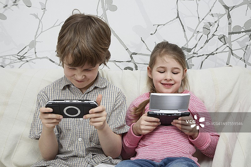 兄妹玩掌上游戏机图片素材