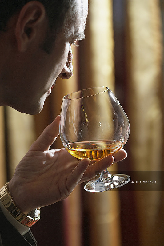 男人手持白兰地酒杯图片素材