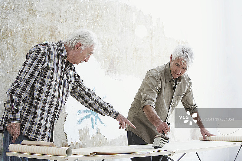 在墙纸上涂胶水的男人们图片素材