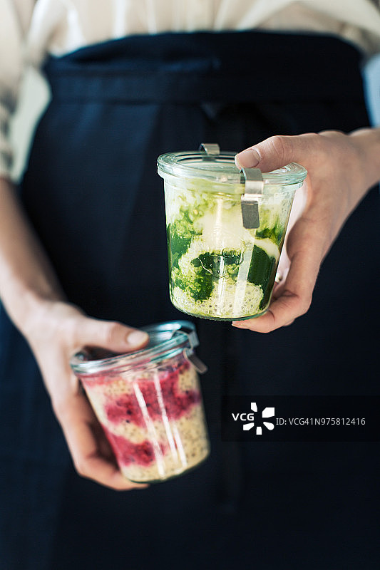 手捧玻璃容器食物的女子（局部）图片素材