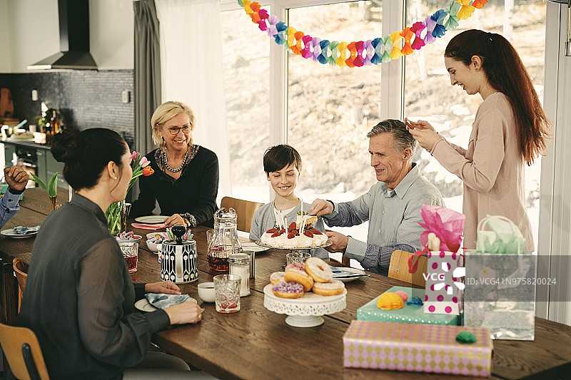 多代同堂的家庭在派对上享用生日蛋糕图片素材