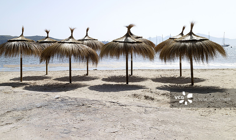 西班牙海滩上的茅草遮阳伞图片素材
