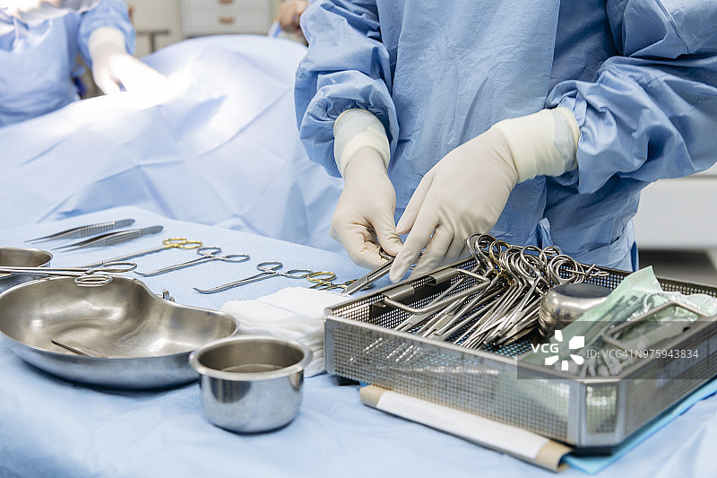 外科医生仔细整理桌子上的医疗工具图片素材
