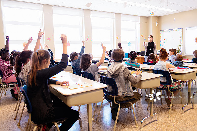 不同民族的学生在课堂上举手图片素材