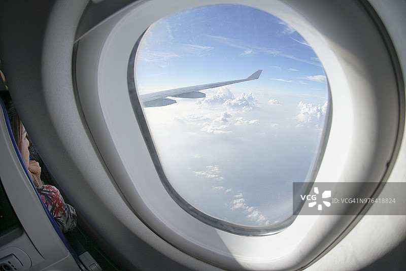 亚裔女人看着飞机窗外图片素材