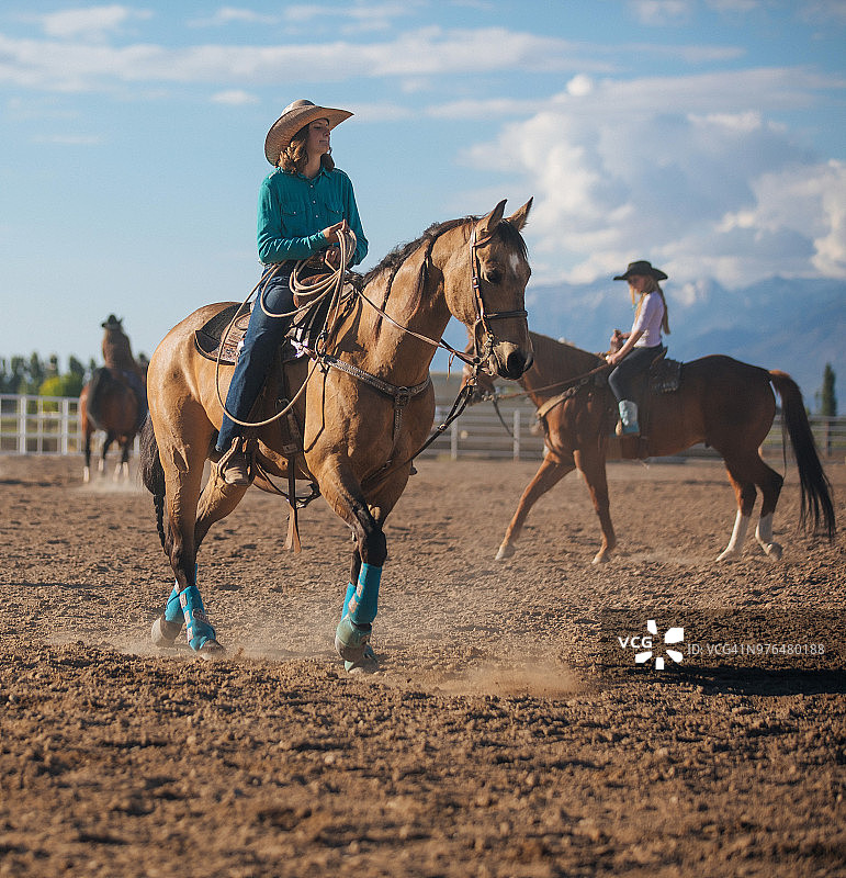 年轻女牛仔在竞技场上骑马图片素材