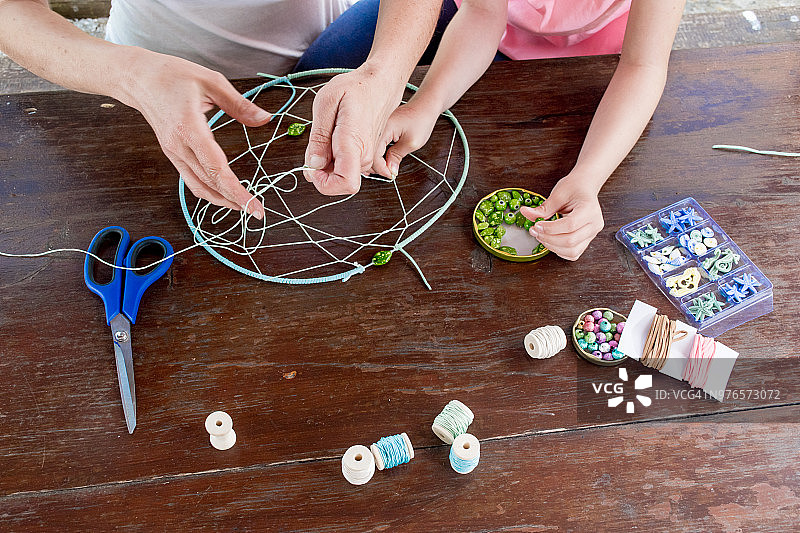 母亲帮助女儿制作捕梦网图片素材