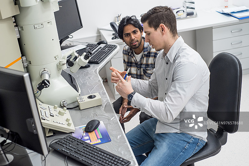 讨论场发射电子显微镜研究结果的男性科学家图片素材