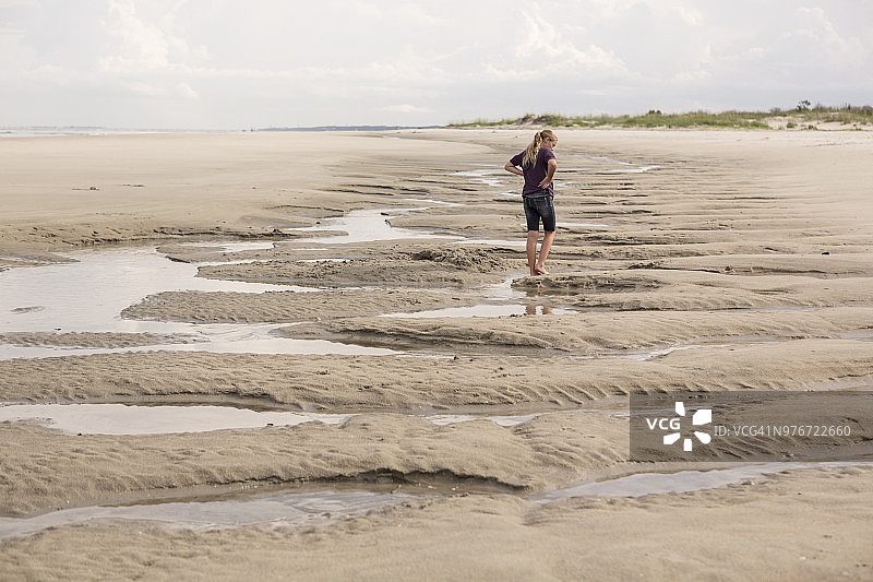 在退潮时于海滩上行走的女孩图片素材