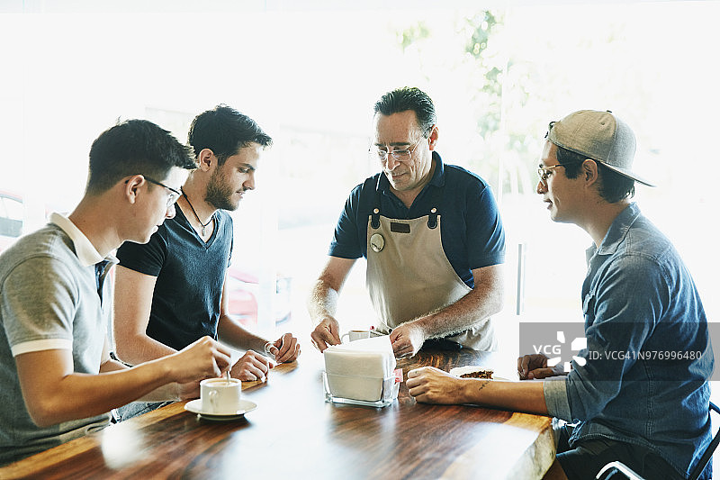 店主在面包店的柜台为三位朋友提供咖啡图片素材