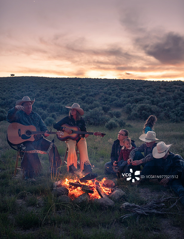 牛仔们围坐在篝火旁弹吉他和唱歌图片素材