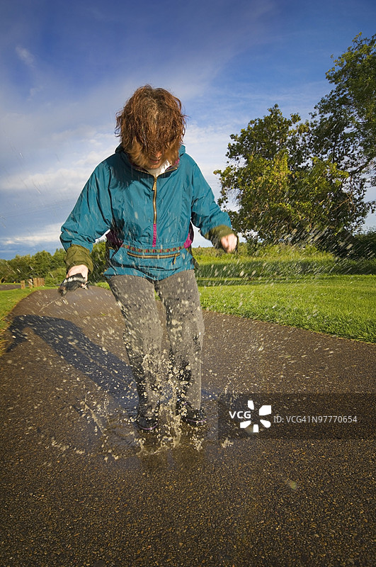 女人在雨水坑中玩耍图片素材