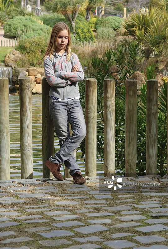 女孩倚靠在柱子上图片素材