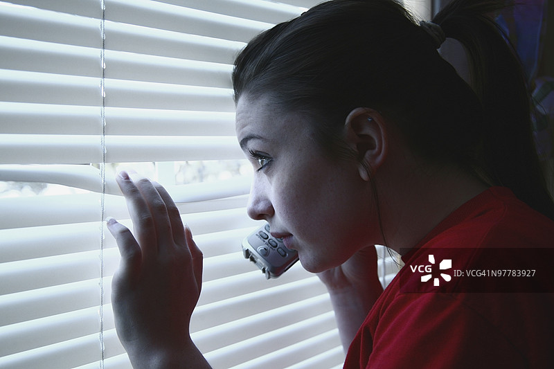少女在打电话，透过窗户偷看图片素材