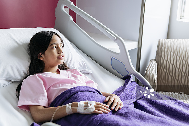 年轻女孩在医院里向窗外看图片素材