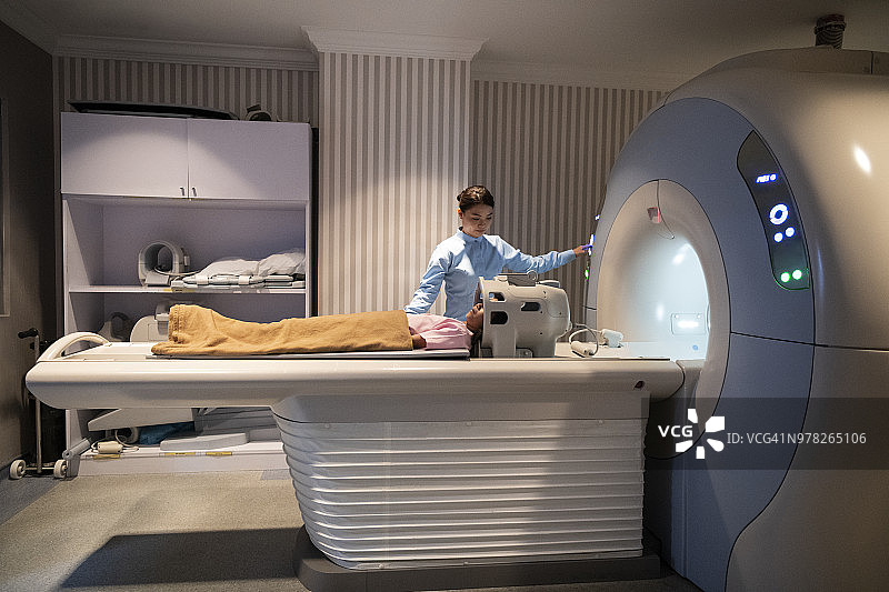 护士操作核磁共振机器，病人躺在里面图片素材